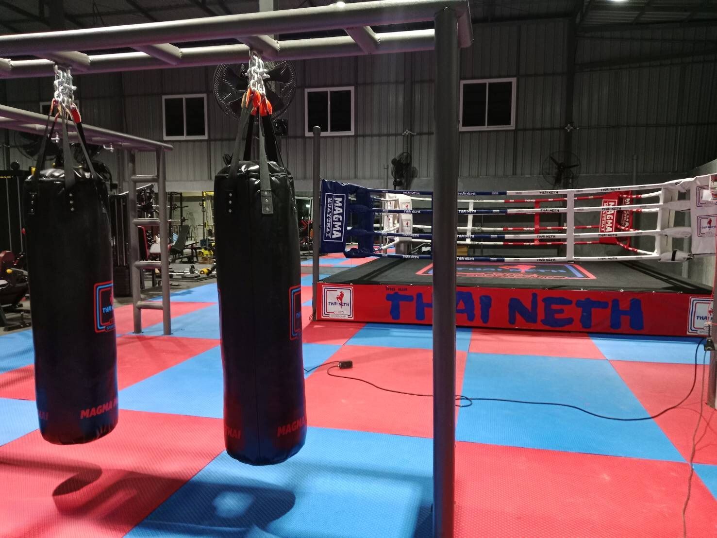 Punching bags and boxing ring at Thaineth Gym and Sport Camp Pattaya.