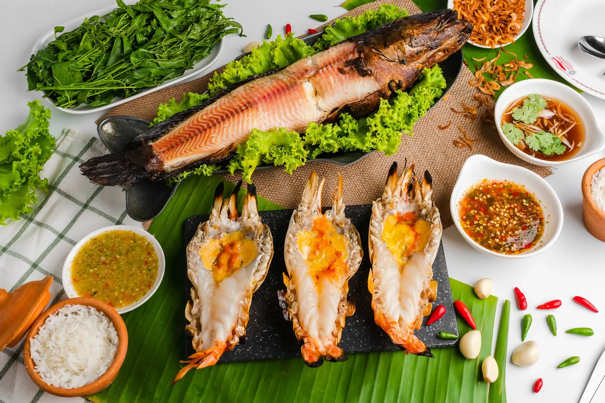 Grilled snakehead fish served with grilled prawns, fresh vegetables, and dipping sauces at Mae La Pla Phao, Sing Buri 