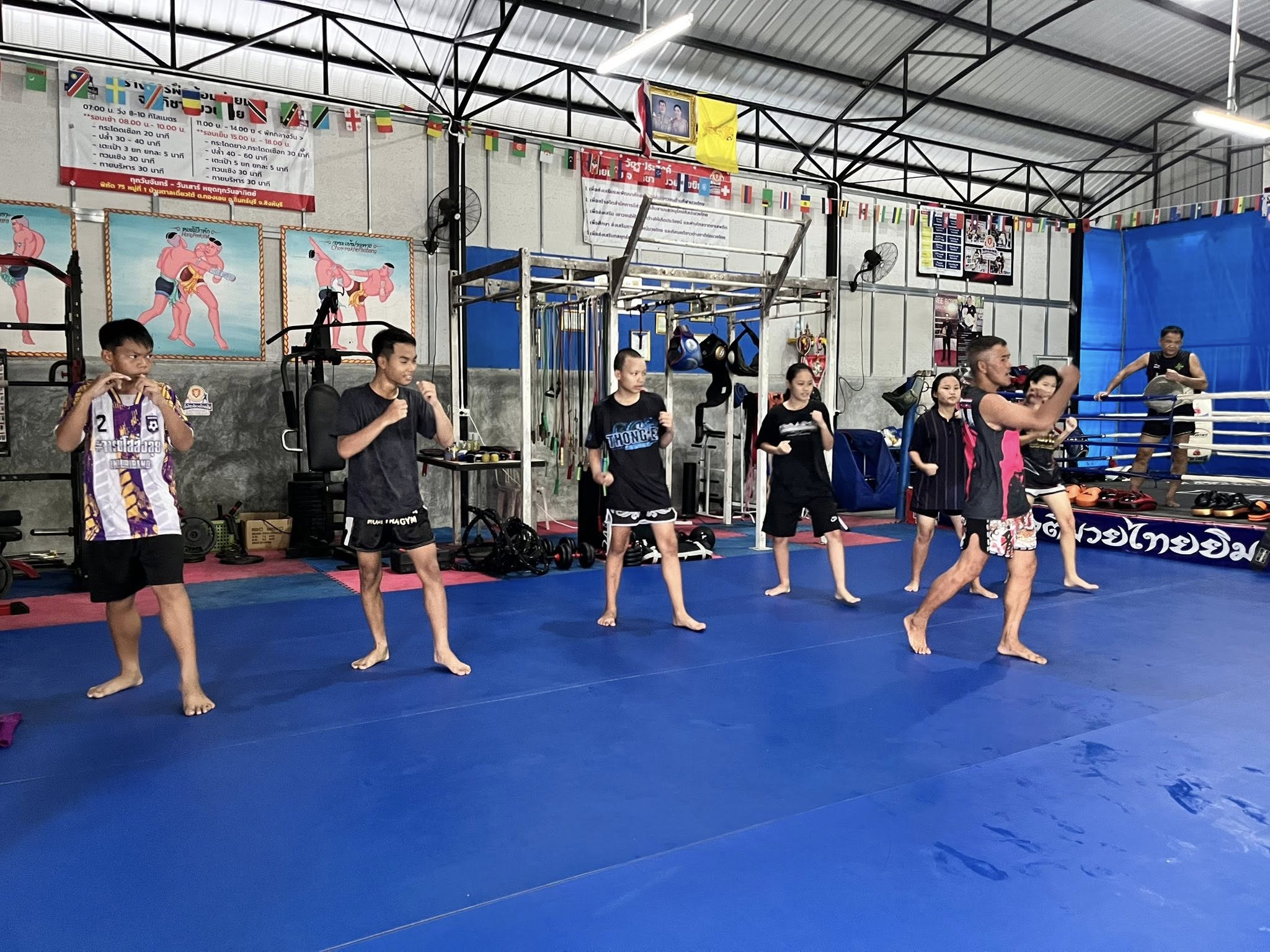 A group class practicing Muay Thai stances together at J. Aphichat Muay Thai Gym, Sing Buri