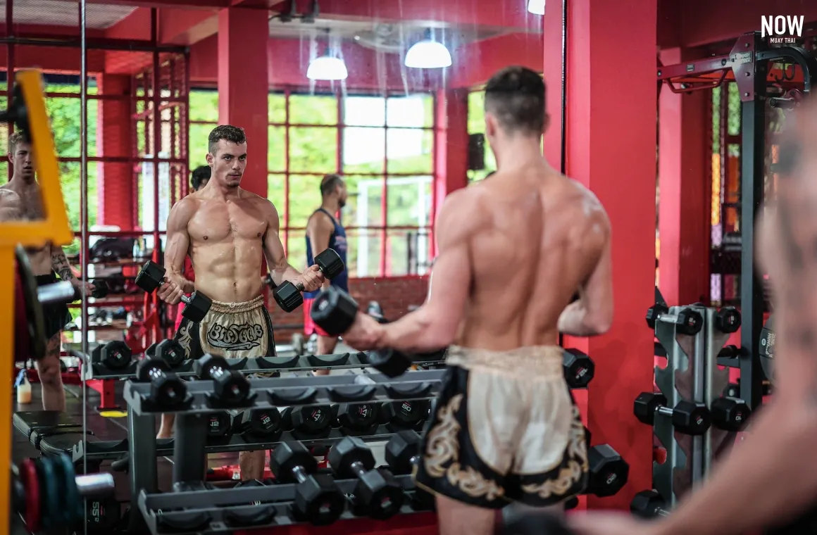 A man choosing weights at Khunsuek Muay Thai