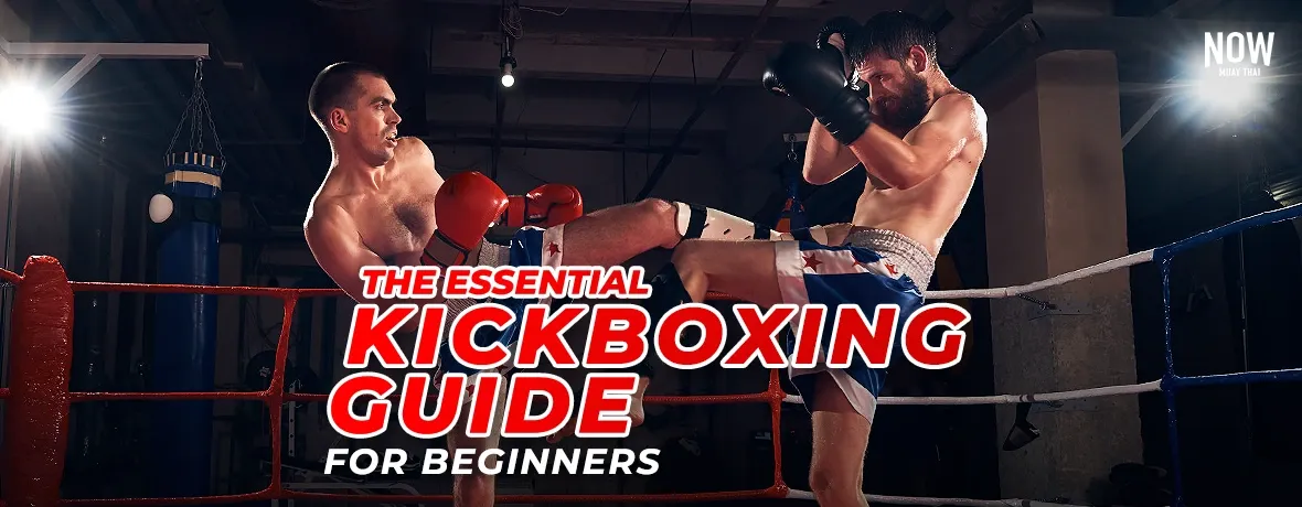 A wide-angle, action shot of two professional male fighters engaging in a fierce kickboxing match within a brightly lit ring during a championship event