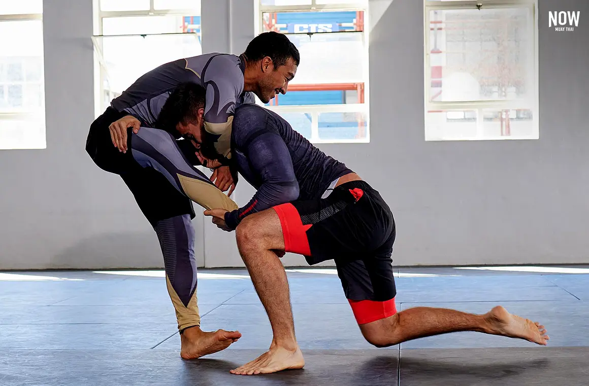 MMA fighters practicing Brazilian Jiu-Jitsu (BJJ) grappling skills on the mat, showing how MMA offers a pathway for fitness, self-defense, and competition worldwide.
