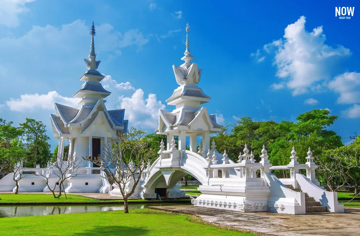 Wat Rong Khun, White Temple, Chiang Rai, Thailand, intricate white facade, sparkling details, clear sky, Thai architecture, tourist attraction, travel destination, spiritual landmark.