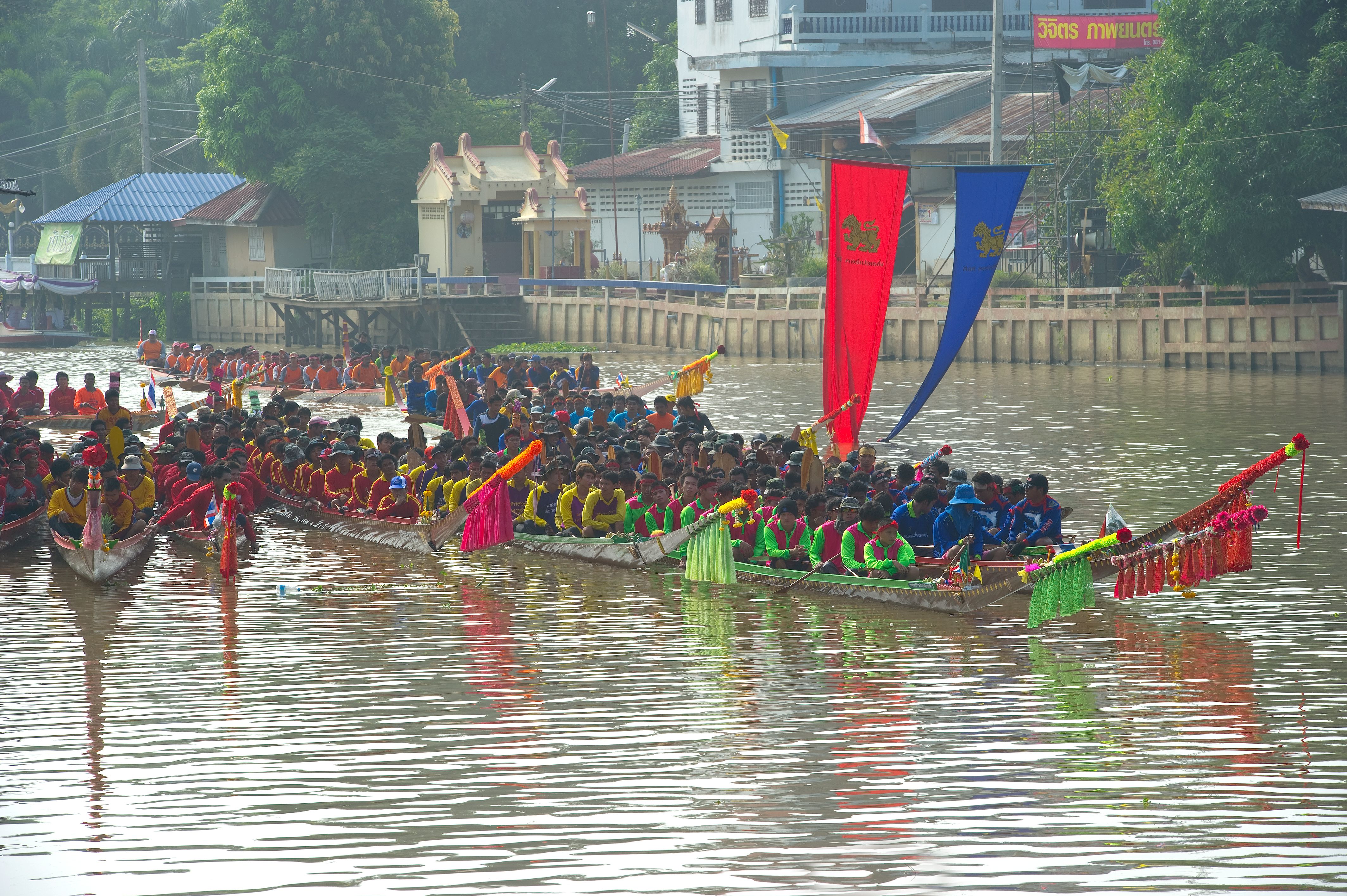 A long-boat racing team rowing in full force during a traditional race on the Noi River, Sing Buri