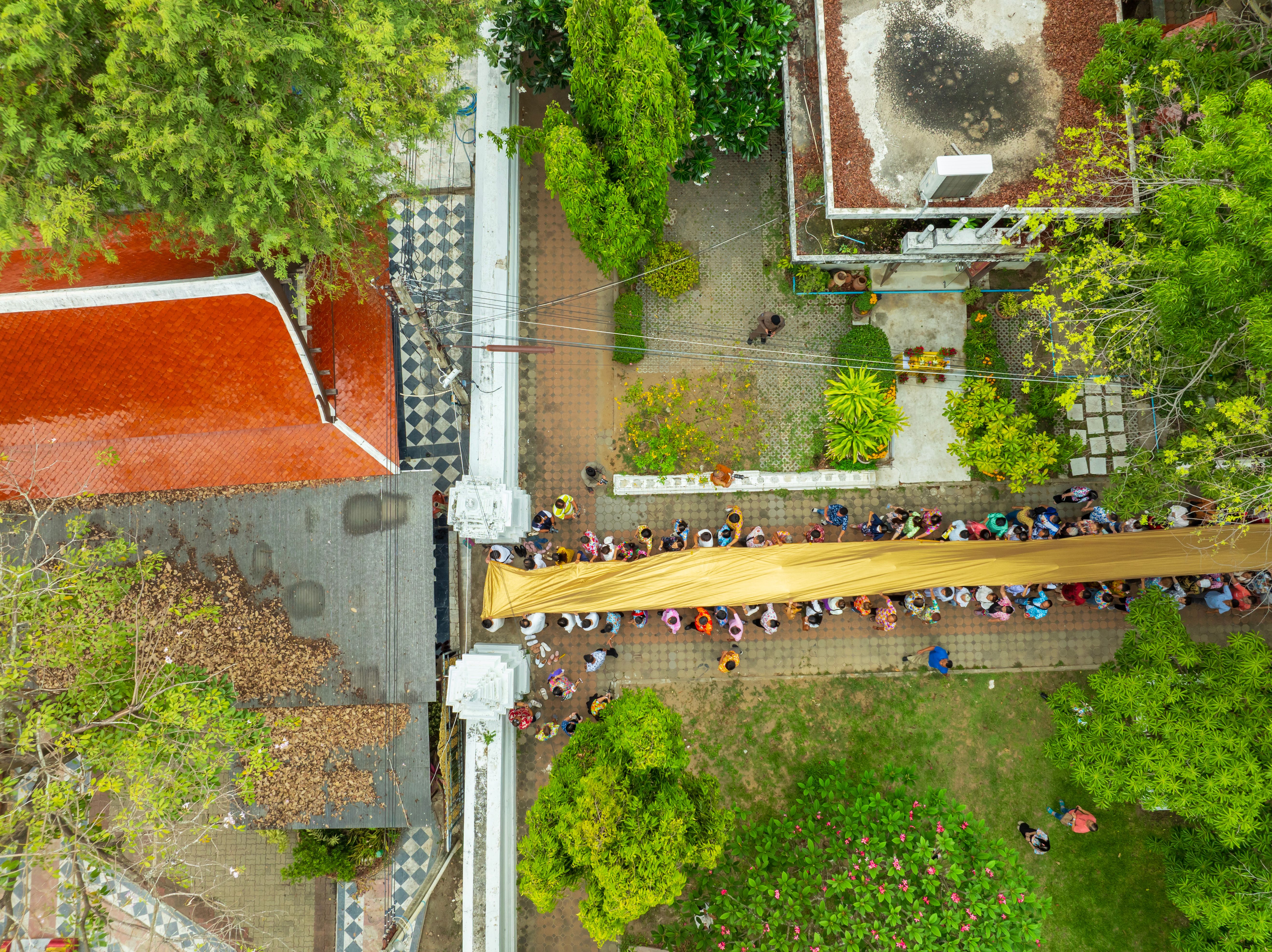 People holding a long ceremonial cloth together at Wat Phra Non Chaksi during Songkran, Sing Buri