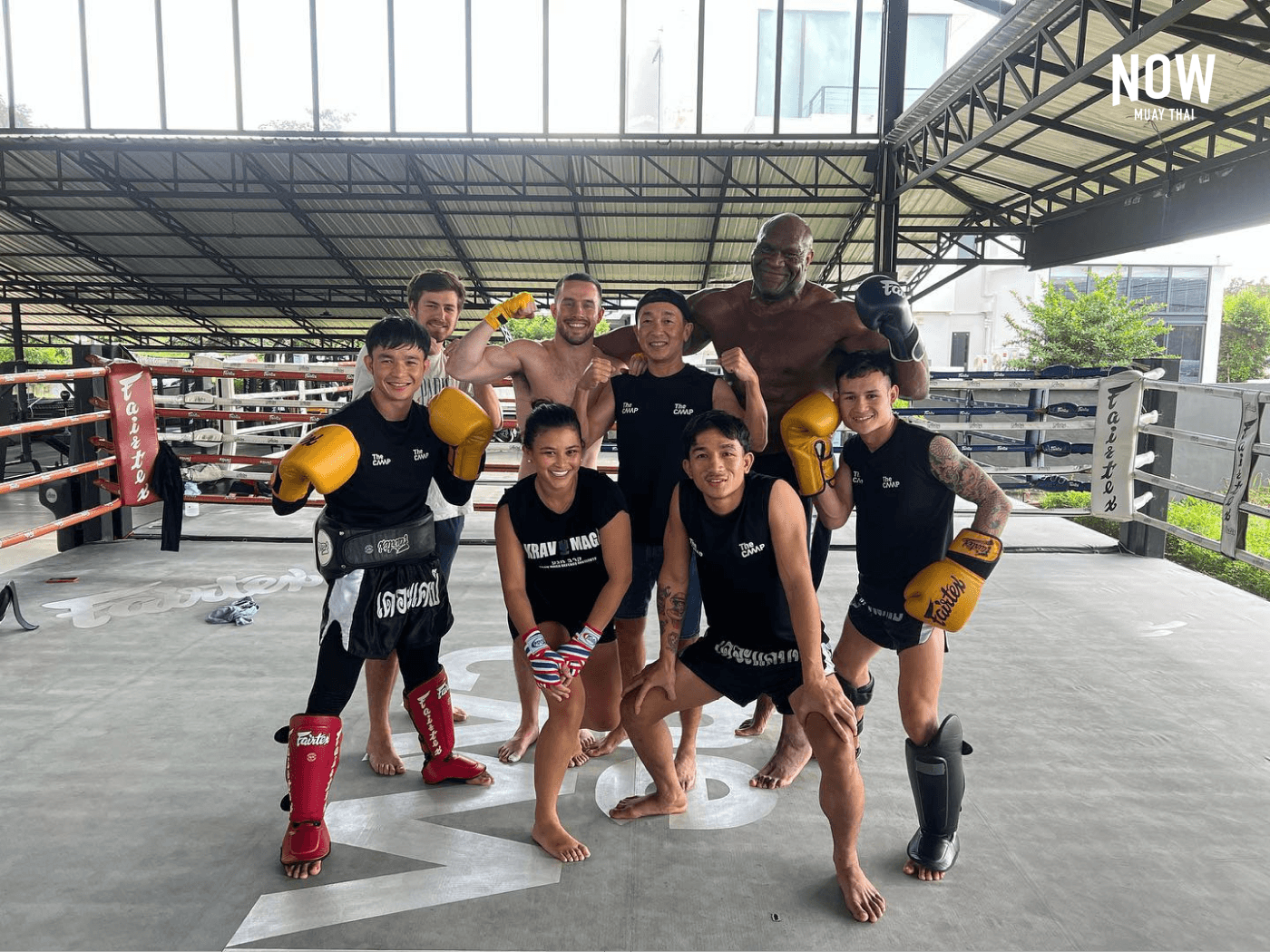 A group of gym members pose in a boxing ring at The Camp Muay Thai Gym in Chiang Mai