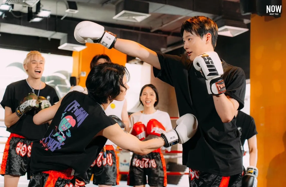 2 people practicing muay thai at RSM Muay Thai and 3 people standing in the back, cheering them up