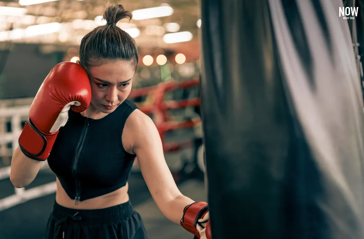 A woman practices Muay Thai, showcasing focus and determination. Muay Thai’s rigorous training helps build mental resilience, teaching the ability to stay centered and composed under stress—a powerful boost for mental health.