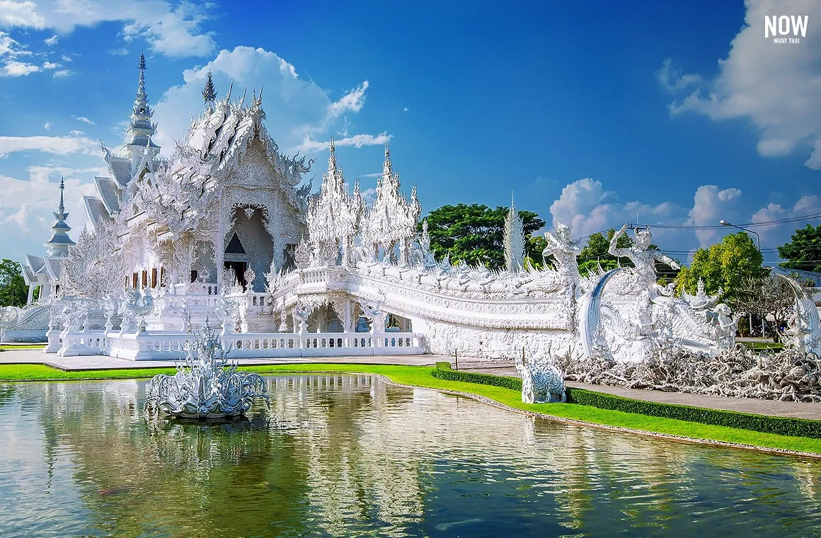 Wat Rong Khun - A stunning temple designed by artist Chalermchai Kositpipat, featuring intricate white architecture adorned with mirrored glass, symbolizing the purity of Buddha. This iconic site in Chiang Rai is a must-visit for its unique artistry and spiritual significance.
