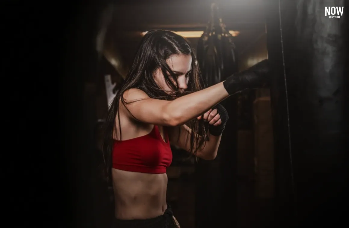 A woman performing rapid punch combo drills during a Muay Thai training session.