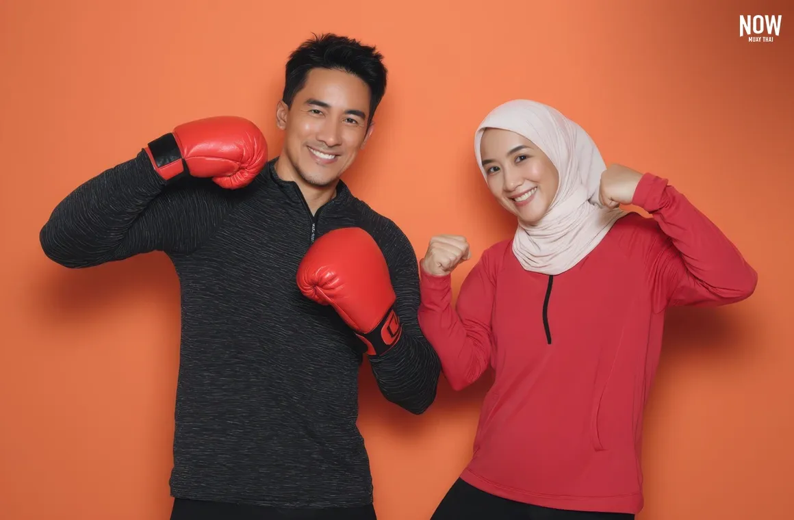 A Muslim couple posing in Muay Thai-style fitness stance, smiling confidently against an orange background.