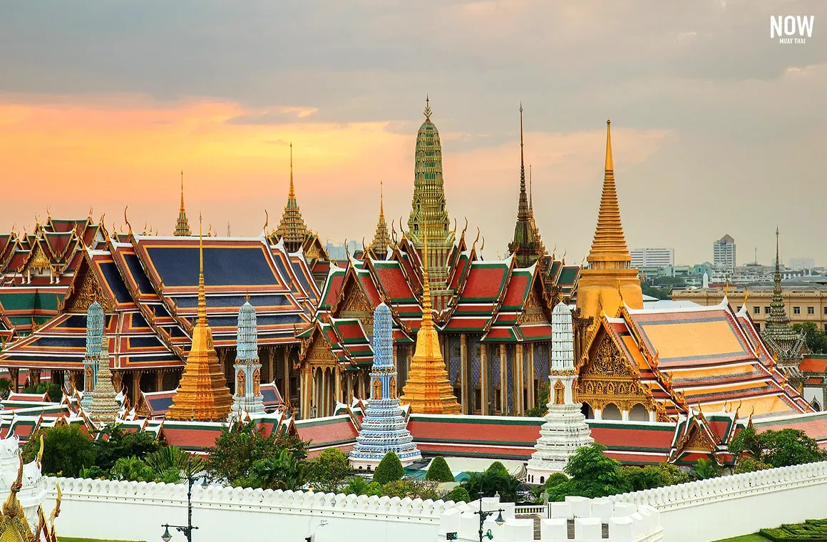 A stunning view of the Grand Palace and Wat Phra Kaew, illuminated in golden light, symbolizing the cultural and historical significance of the golden era of Muay Thai.