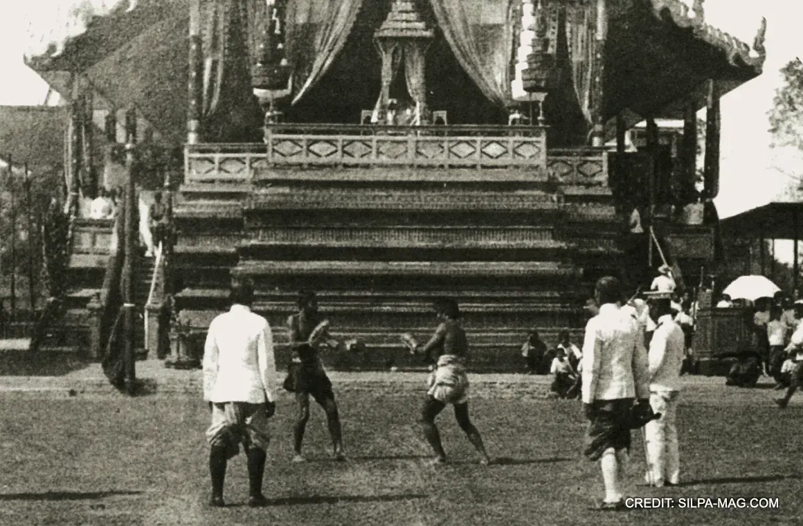 An image of King Rama V, known for his great admiration of Muay Thai, watching a traditional Thai boxing match from his royal seat.