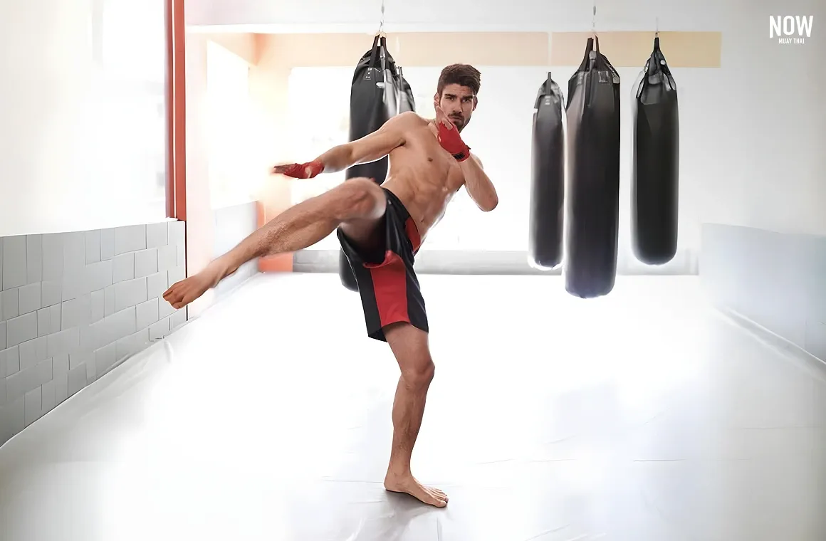 A beginner practices Muay Thai kicking techniques, focusing on the powerful shin kick, which uses the leg from the hip to the shin as a striking tool, much like swinging a sturdy stick.