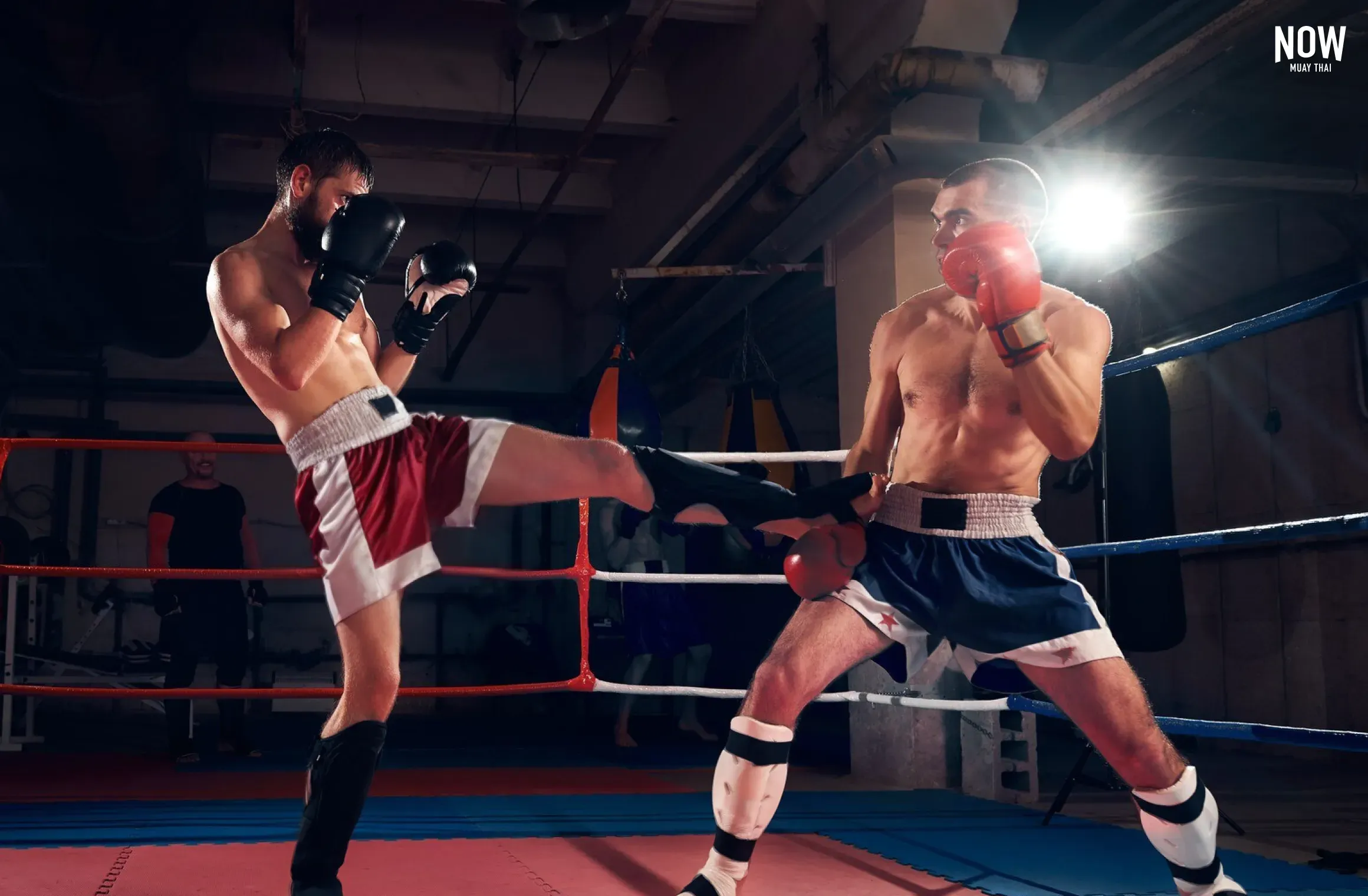 Two Muay Thai fighters sparring in the ring wearing padded sparring gloves for safe partner training and technique practice.
