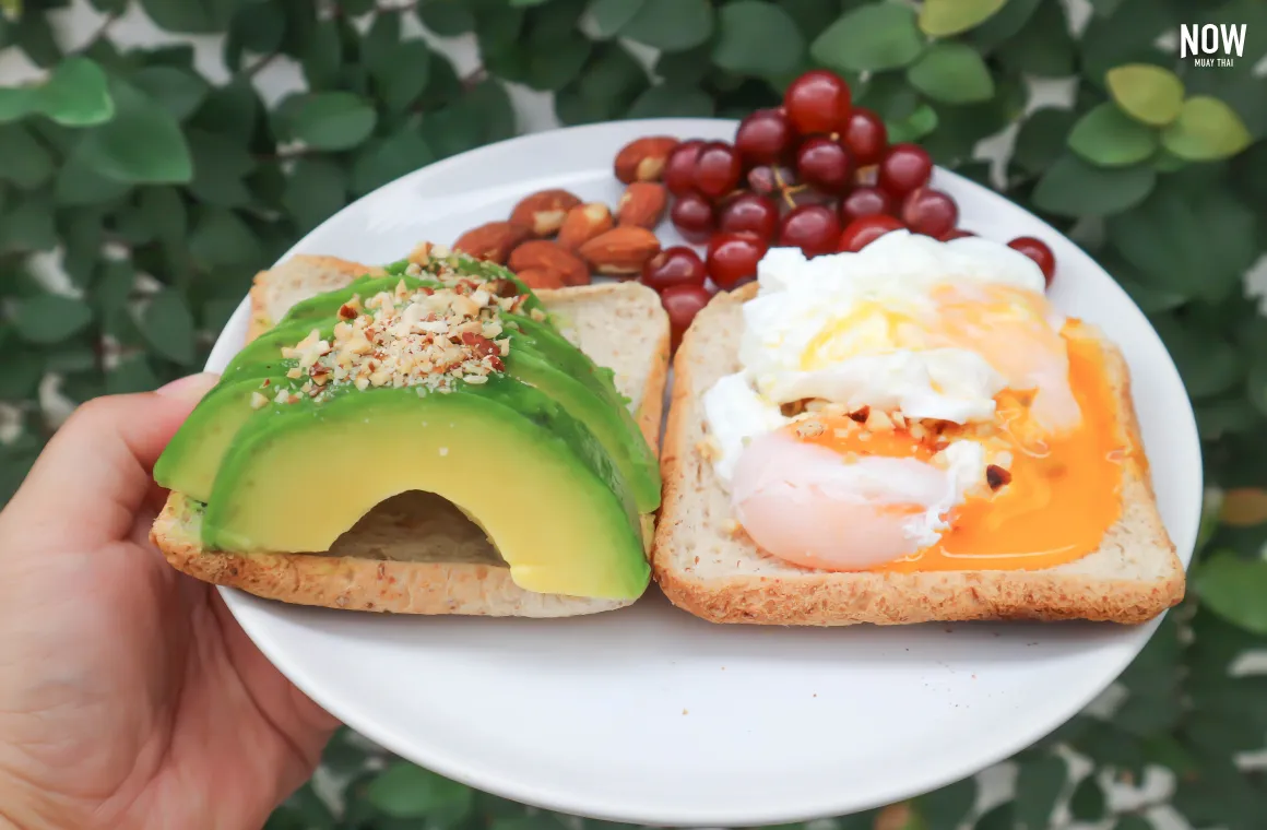 A balanced post-workout meal featuring egg-based dishes served with whole-grain toast and avocado.
