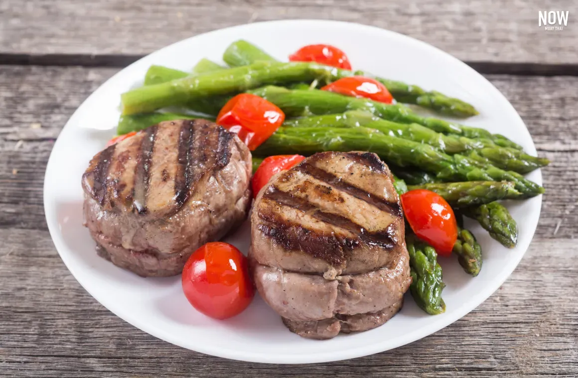 A juicy lean beef steak served with vibrant asparagus and cherry tomatoes