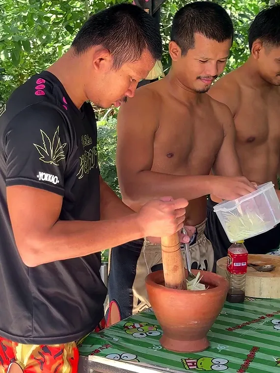 Superlek is preparing lunch with the younger members at boxing camp.