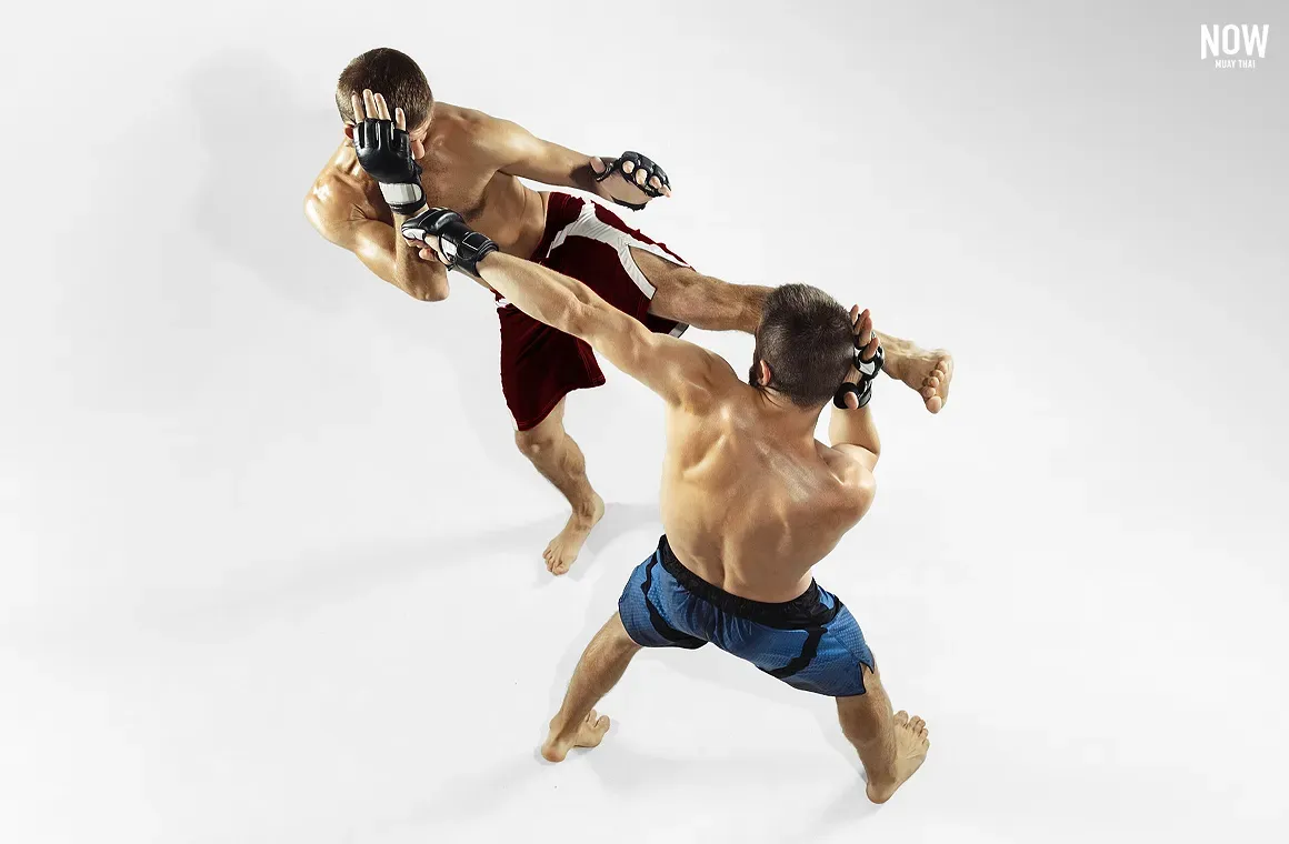 Two fighters demonstrate the Muay Thai parry technique, which not only blocks an attack but also positions you to counter, helping control the flow of a confrontation.