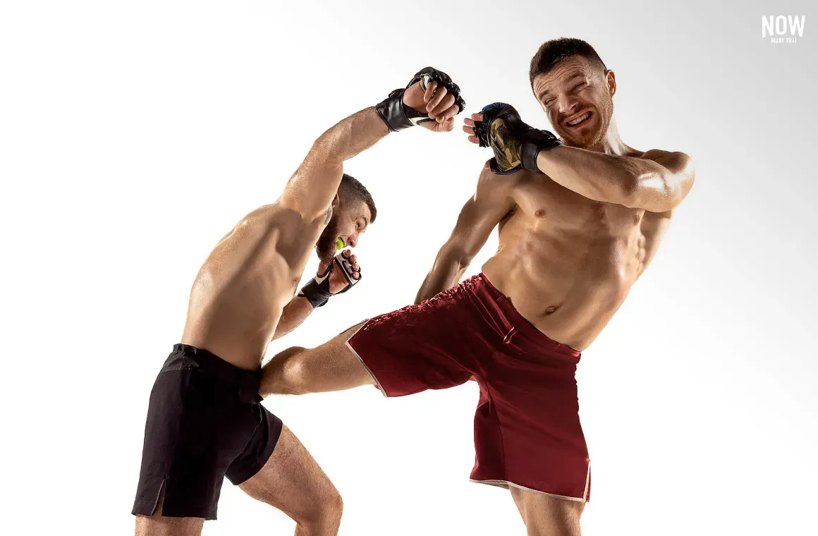 Two fighters demonstrate the technique of "getting out of the way" using footwork to step to the side or back to avoid an attack, then quickly moving into a better position for a counter strike with a roundhouse kick to the body.