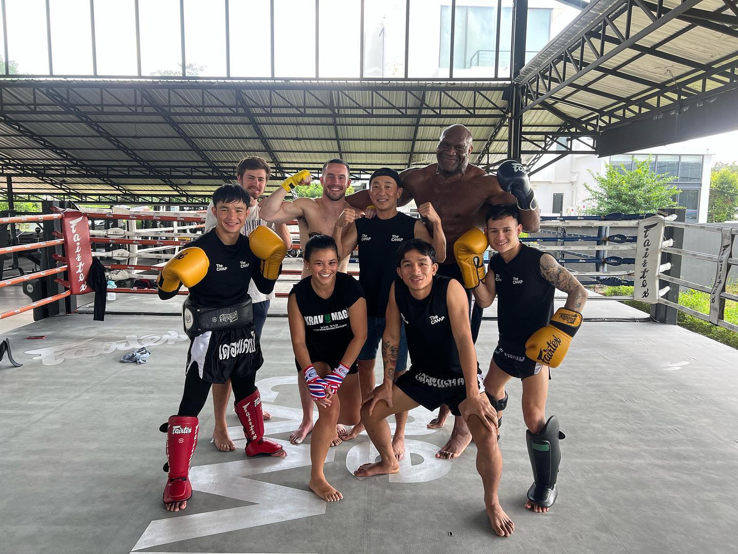  A group of gym members pose in a boxing ring at The Camp Muay Thai Resort and Academy in Chiang Mai
