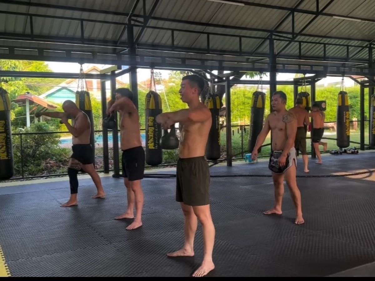 Students are practicing mirror Muay Thai, mimicking movements from the trainer. 