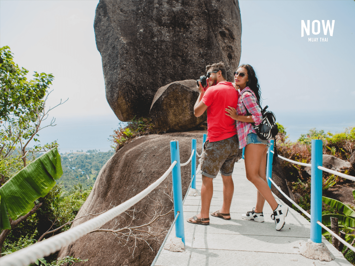 Couple standing on the viewing platform at Overlap Stone on Koh Samui and taking photos.